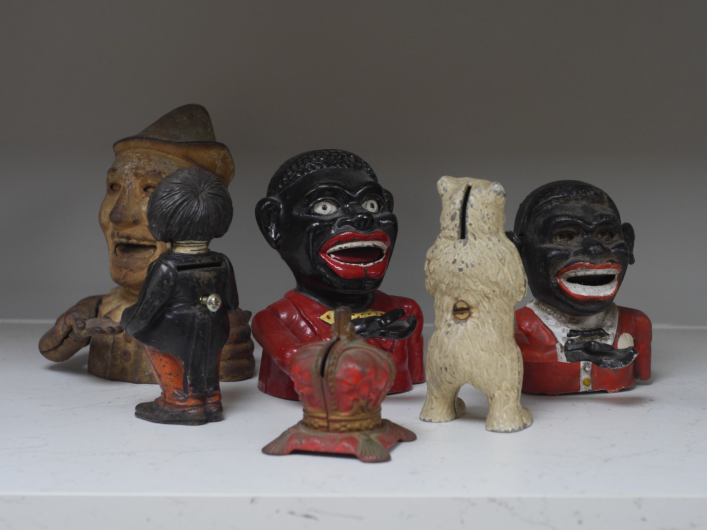 Six various metalware money boxes to include to jolly money banks, standing bear and one in the form of a crown. Condition - fair with general wear